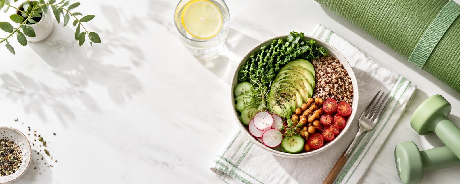 Healthy bowl, water and a yoga mat on a bright table